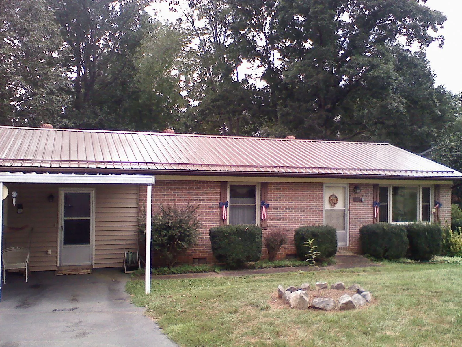 Bronze metal roof and carport on a brick ranch home — Roof Repair work by our crew in Litchfield